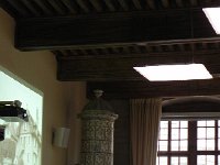 Nikon Coolpix 094  While the peppy auctioneer managed the sale. Note beautiful old ceramic tile stove in contrast with wall mounted projector